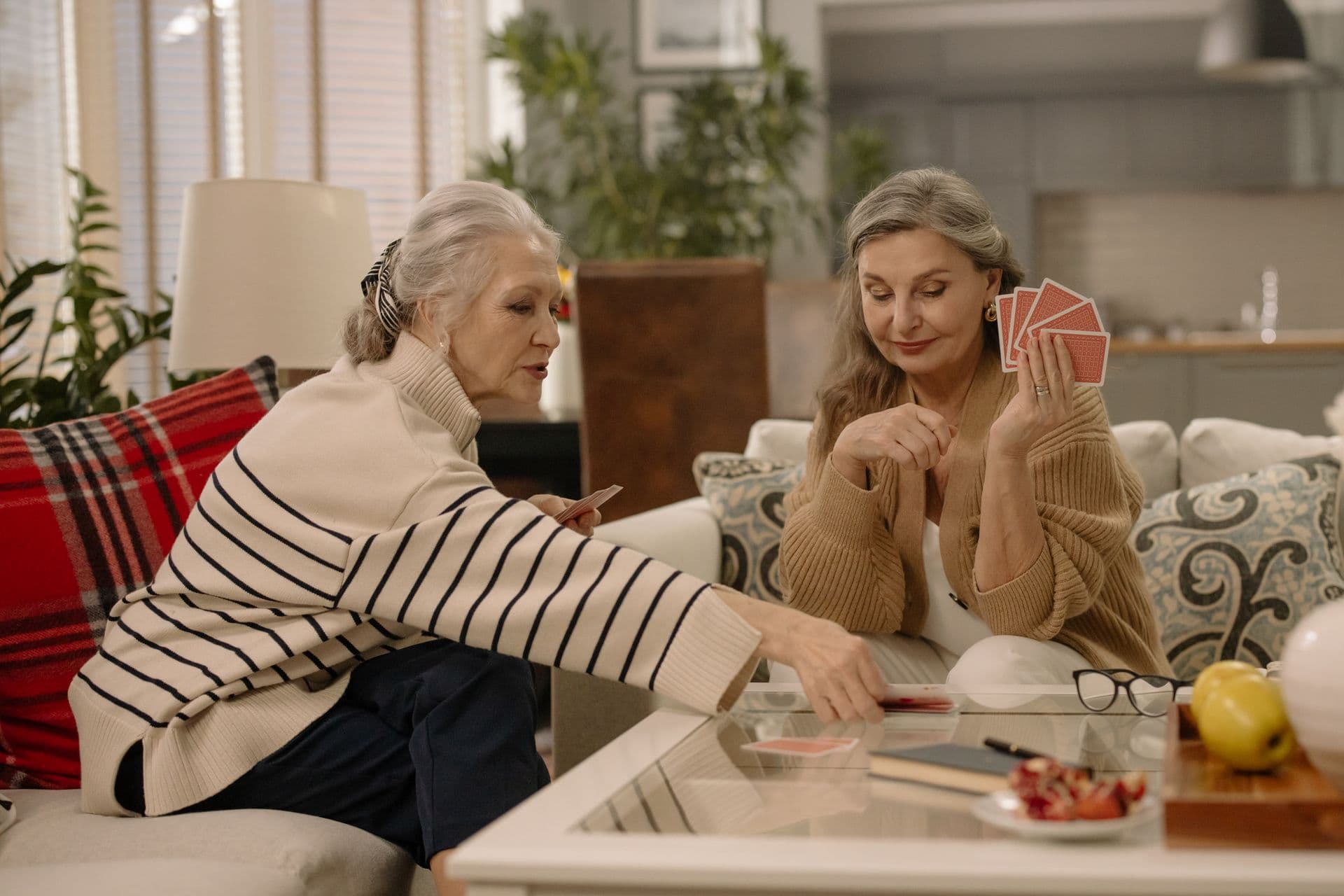 A companion and an older woman laughing together over a board game